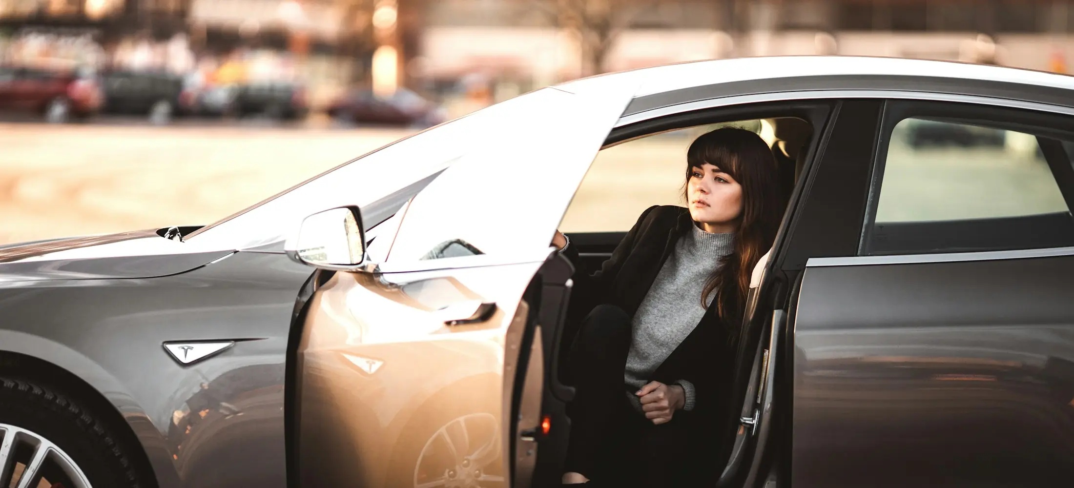 Podnikatelka vystupuje z elektromobilu Tesla